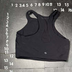 Black sports bra on a gray floor with measurement markings