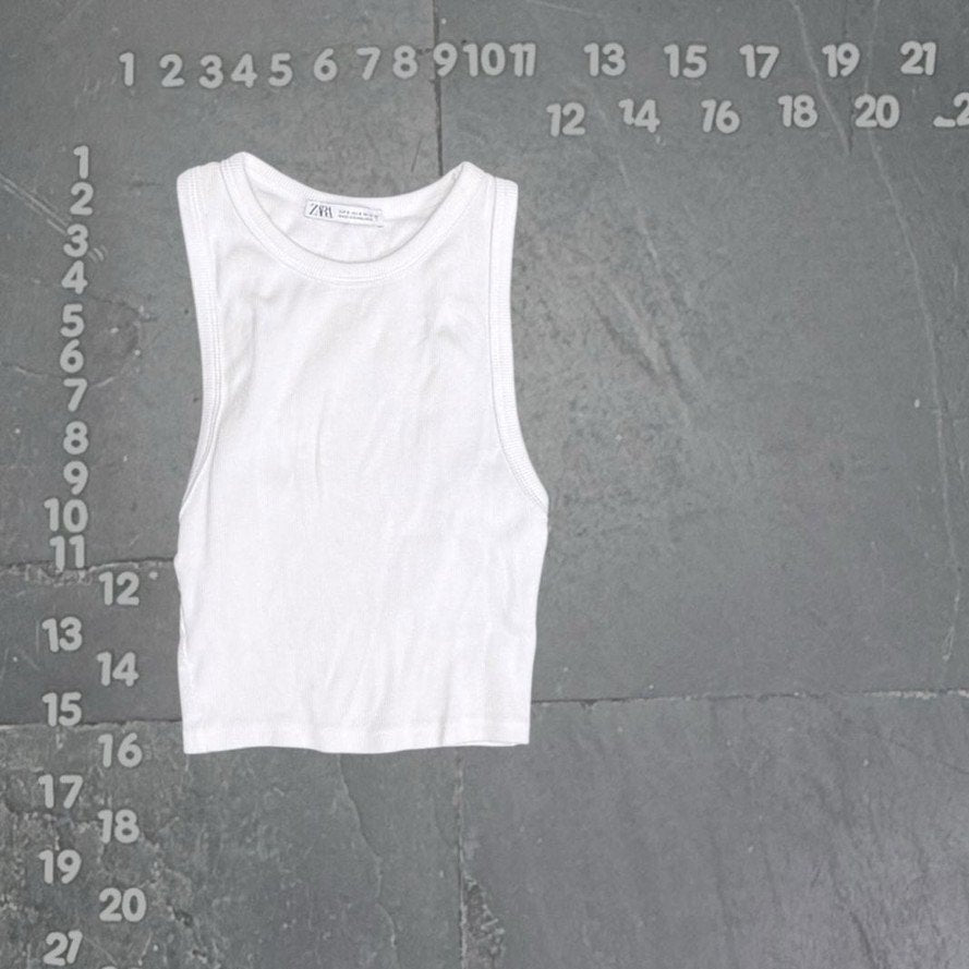 White tank top on a gray background with measurement scale