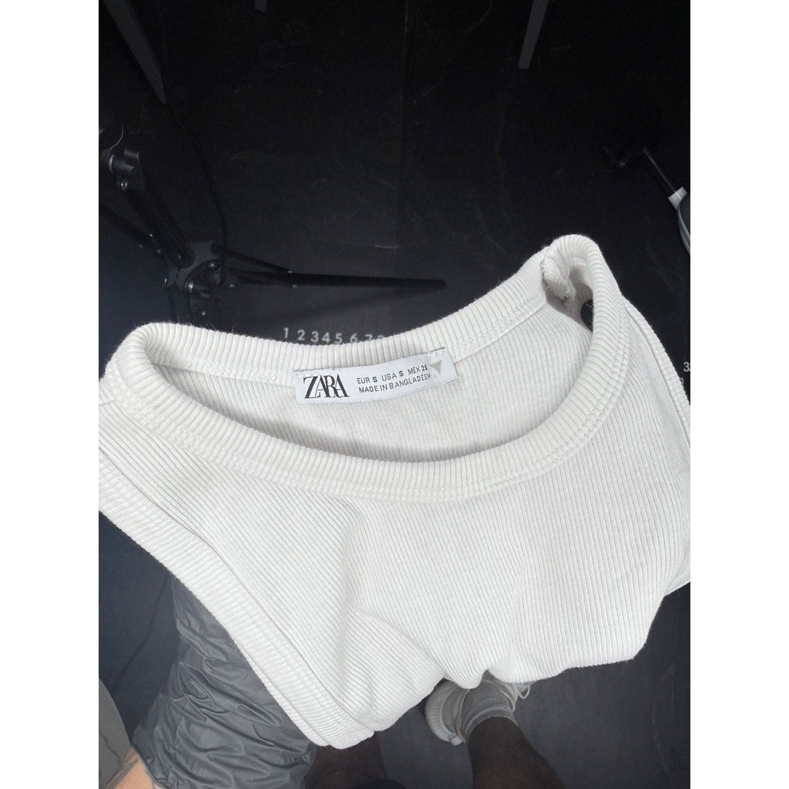 White knit beanie with a brand label on a dark background