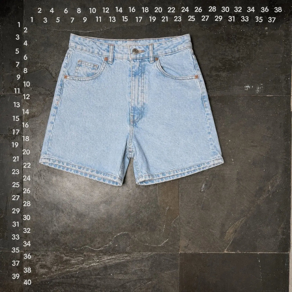 The Room Collective light wash denim shorts, size 4, with five-pocket styling and zip fly.