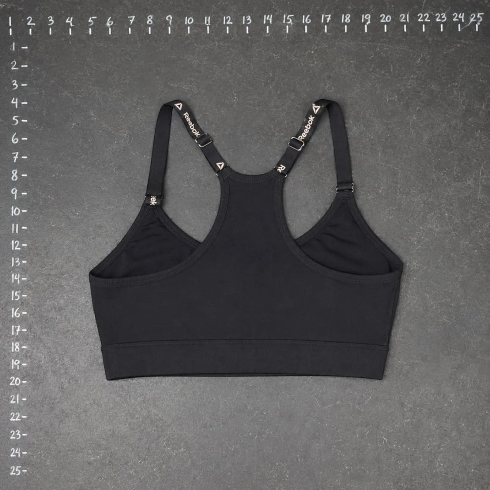 The Room Collective Reebok black logo strap sports bra, size S. Racerback design with adjustable straps.