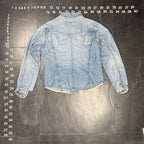 The Room Collective light wash denim trucker jacket with distressed details, frayed hem, and button-up front.