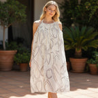 The Room Collective white crinkled halter mini dress with abstract black swirl print and tie-back detail.