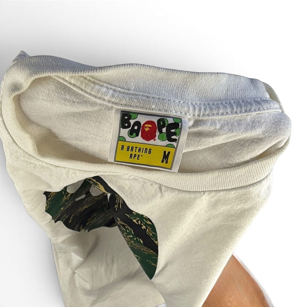 The Room Collective white cotton t-shirt with A Bathing Ape Big Ape Head logo and tiger camouflage print, size M.