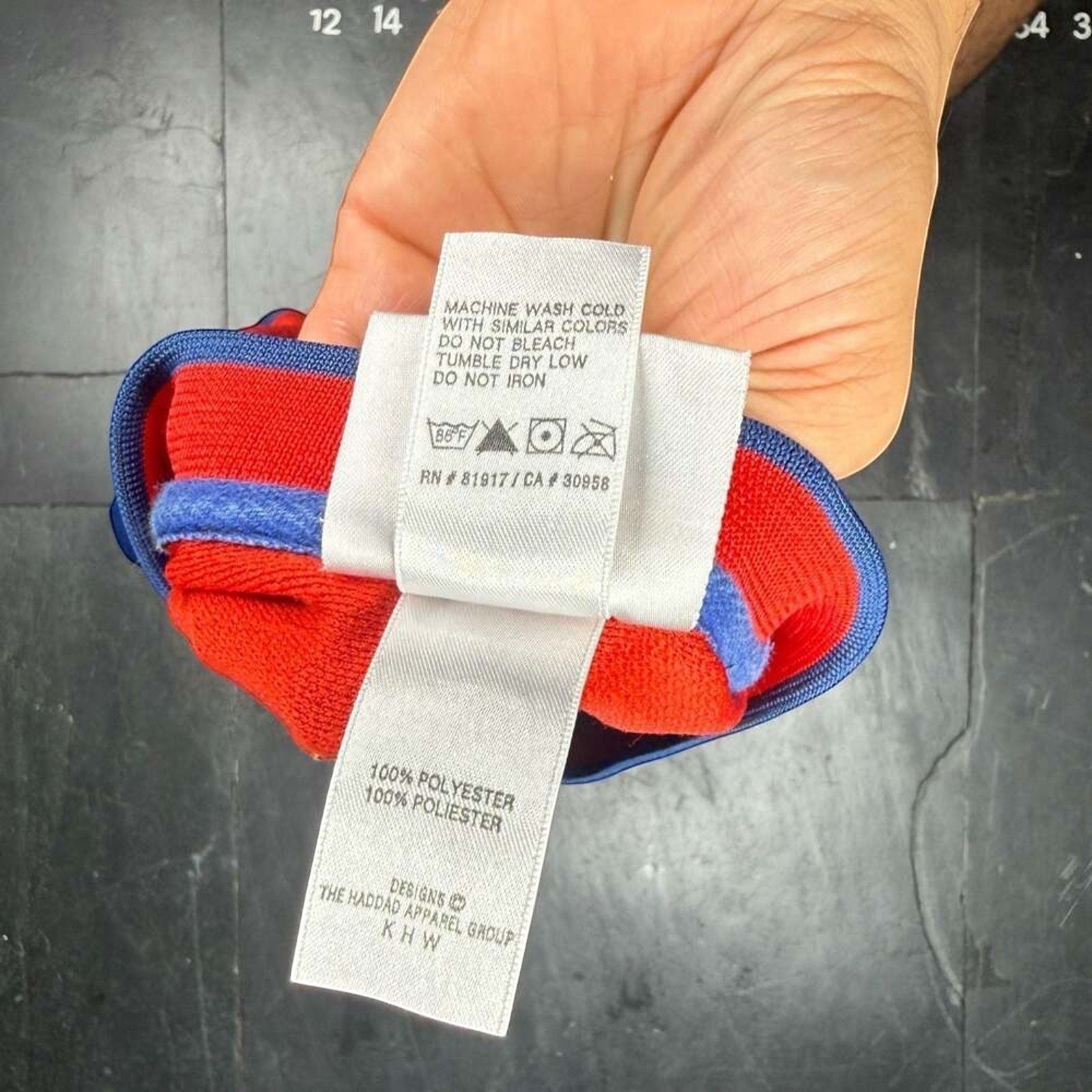 Care label detail on a vintage New York Rangers Brian Leetch Lady Liberty hockey jersey showing fabric content and care instructions.